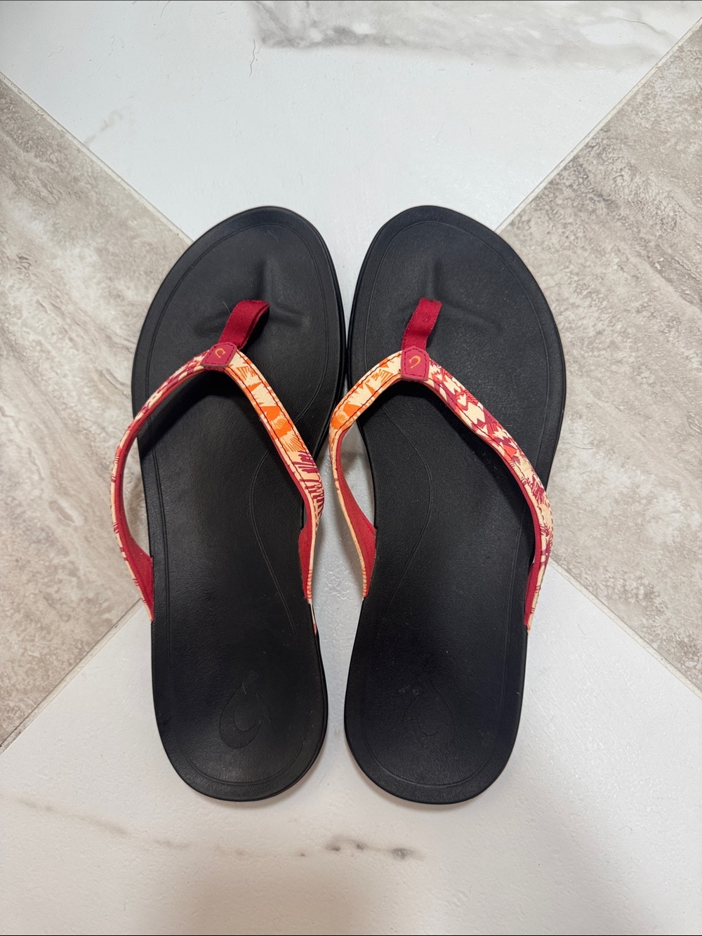 OluKai Black Footbed Flip Flops with Red & Orange Patterned Straps